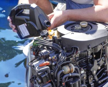 Man pouring and refueling engine motor oil into the engine of a boat, ensuring proper maintenance and performance