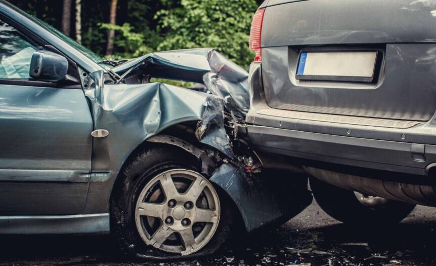 A fender-bender between a blue sedan and a grey SUV. The blue sedan’s hood is visibly damaged and pushed into the SUV.