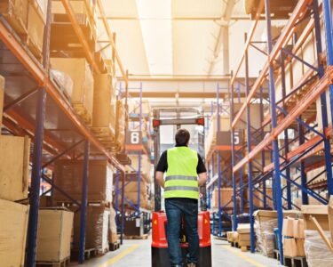 A warehouse employee outfitted with personal protective equipment to follow warehouse safety standards.