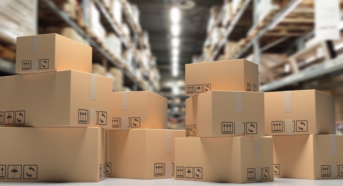 Several cardboard boxes are stacked in a large storage warehouse, illustrating an organized and structured environment.