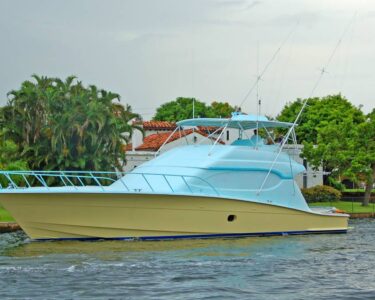 A boat with a new paint job of vibrant colors applied to its hull is surrounded by calm waves and a clear sky.