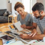 A couple sitting down together in their home to review remodeling plans. Their home is under construction.