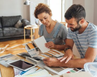 A couple sitting down together in their home to review remodeling plans. Their home is under construction.