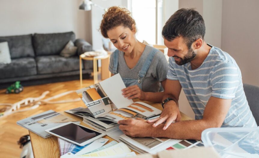 A couple sitting down together in their home to review remodeling plans. Their home is under construction.