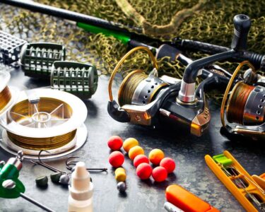 A variety of fishing accessories, including fishing rods, fishing lures, and fishing hooks, resting on a table.