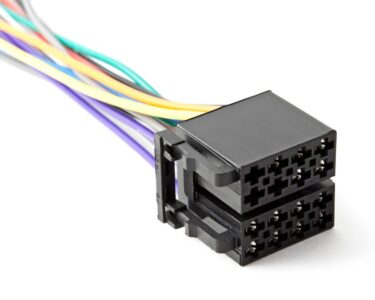 A black 8-cavity connector sits on a white surface with purple, orange, white, blue, red, green, and yellow wires.