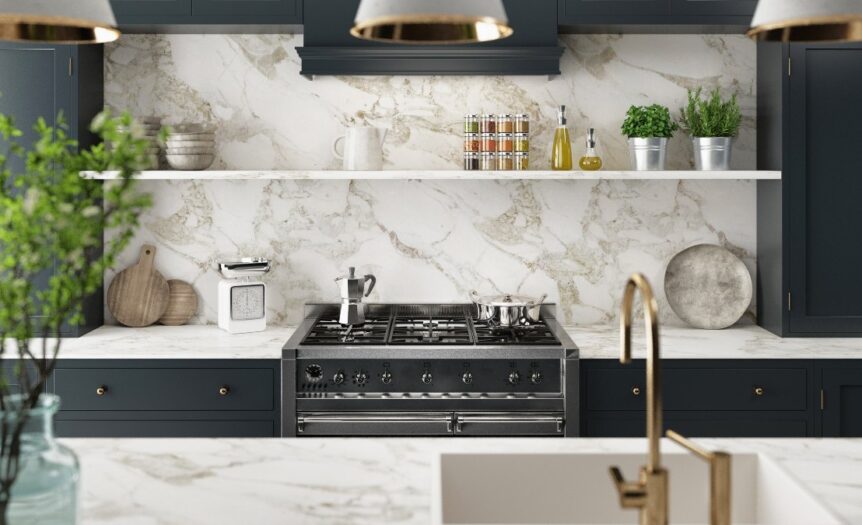 A modern kitchen with black cabinets, a marble countertop, and a marble backsplash. It has white and gold features.