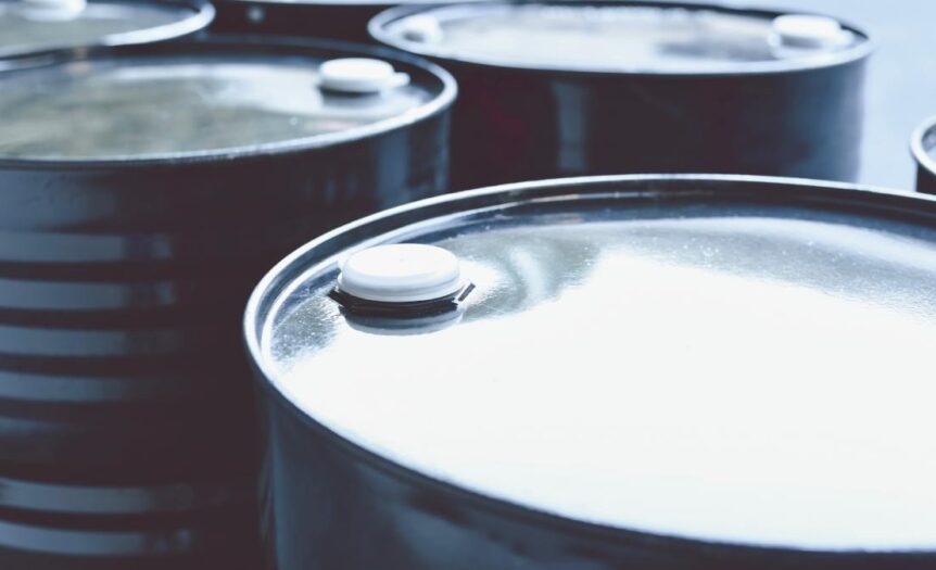 A close-up view shows six black barrels with silver tops and white plugs sitting in two rows of three.